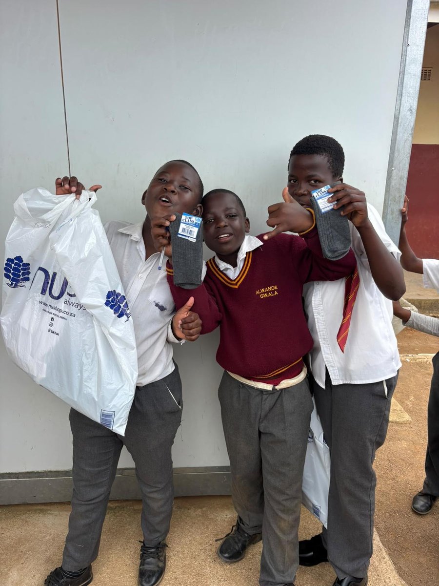 Three schoolboys in their uniforms, showing off their new socks
