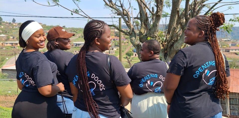 Our five Community Care Givers together, wearing their Opening Doors t-shirts