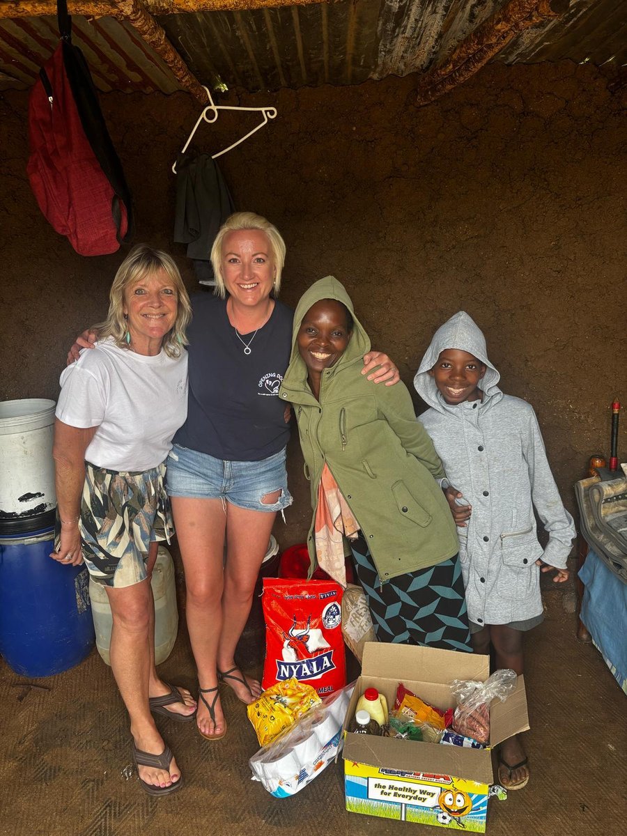 Claire and a volunteer with a mother and her child and their food parcel