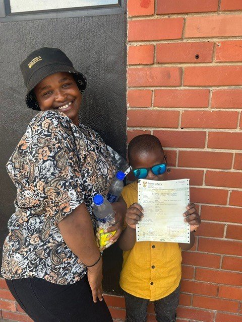 A mother and her son holding his birth certificate