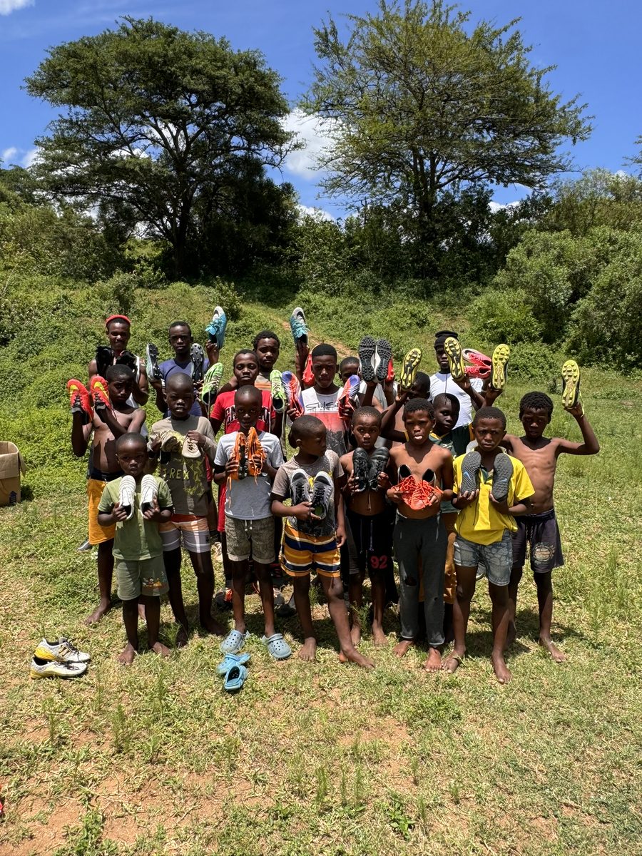 Boys from our football programme holding up their football boots
