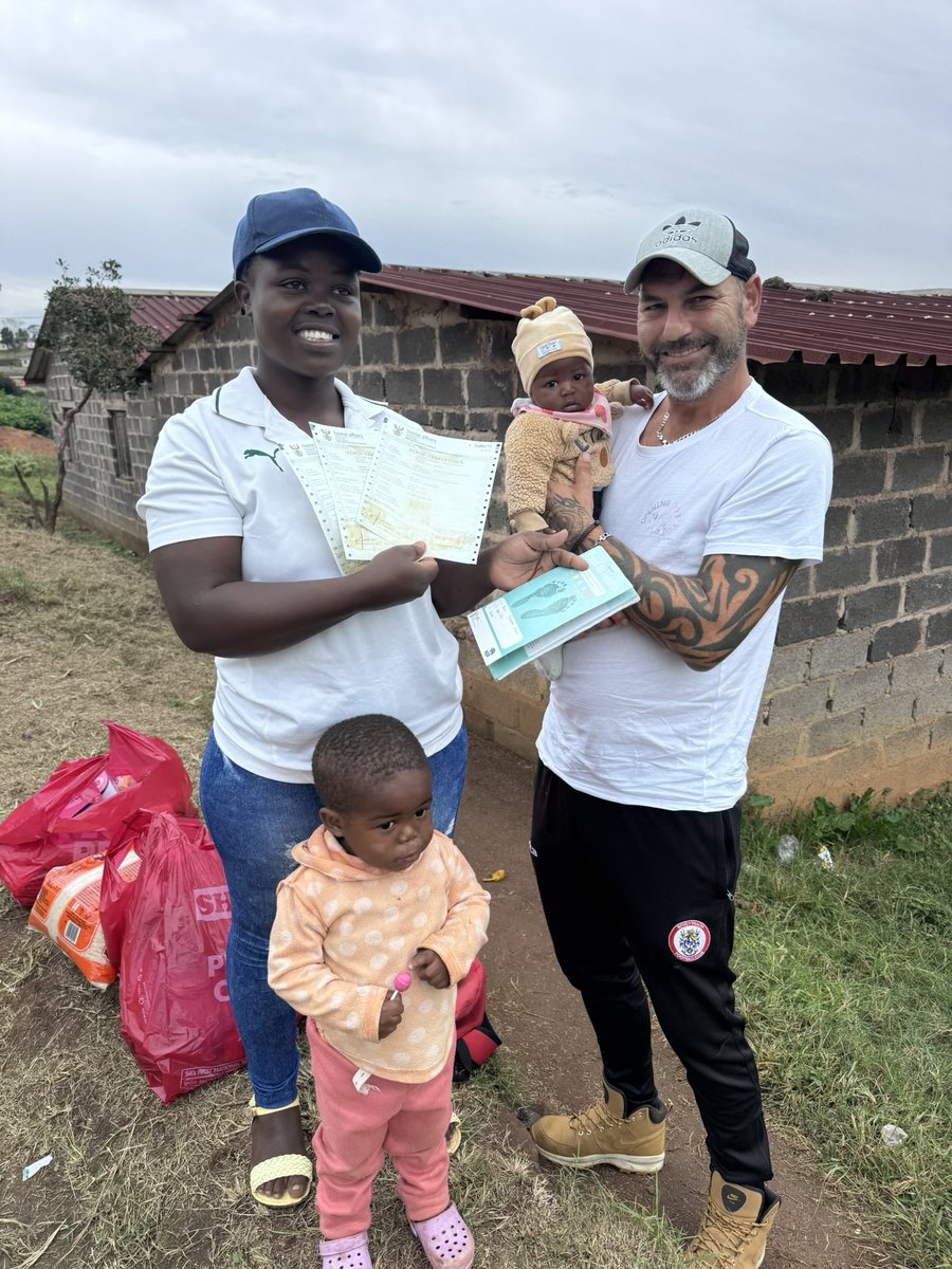 A mother receiving birth certificates and grant documents for her children
