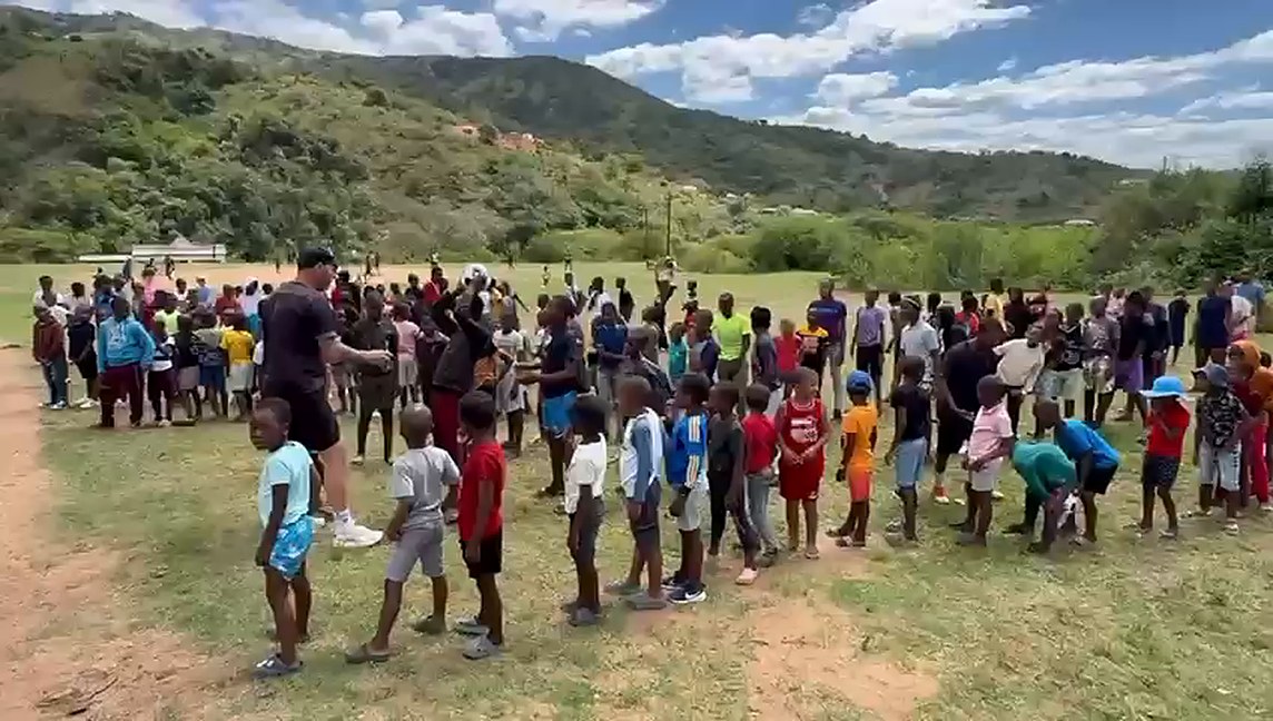 Children lined up on the field with the hills behind during a community sports day