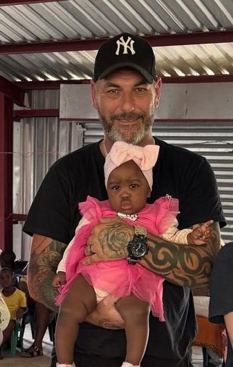 Jay Revell holding a baby from the community