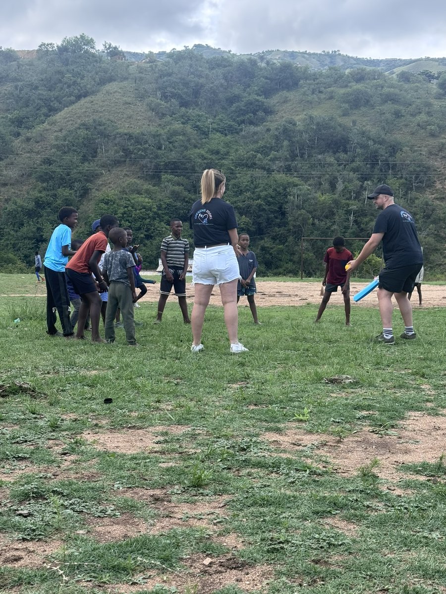 Volunteers coaching a group of children in a sports session