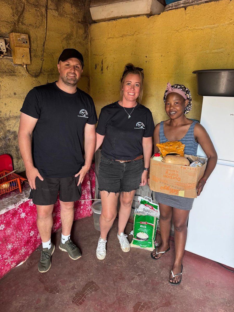Two Opening Doors volunteers delivering a food parcel to a mother at home