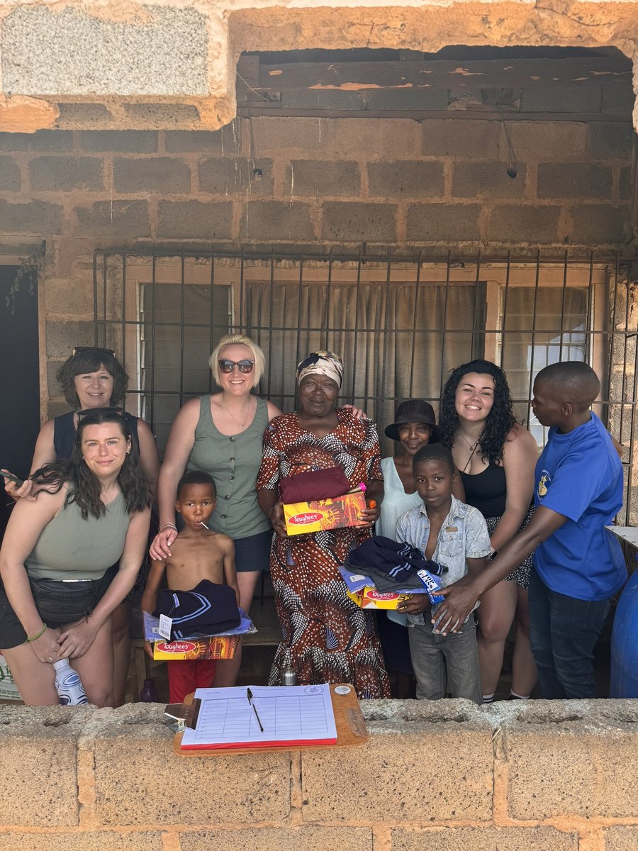 Volunteers delivering school uniforms and supplies to a family