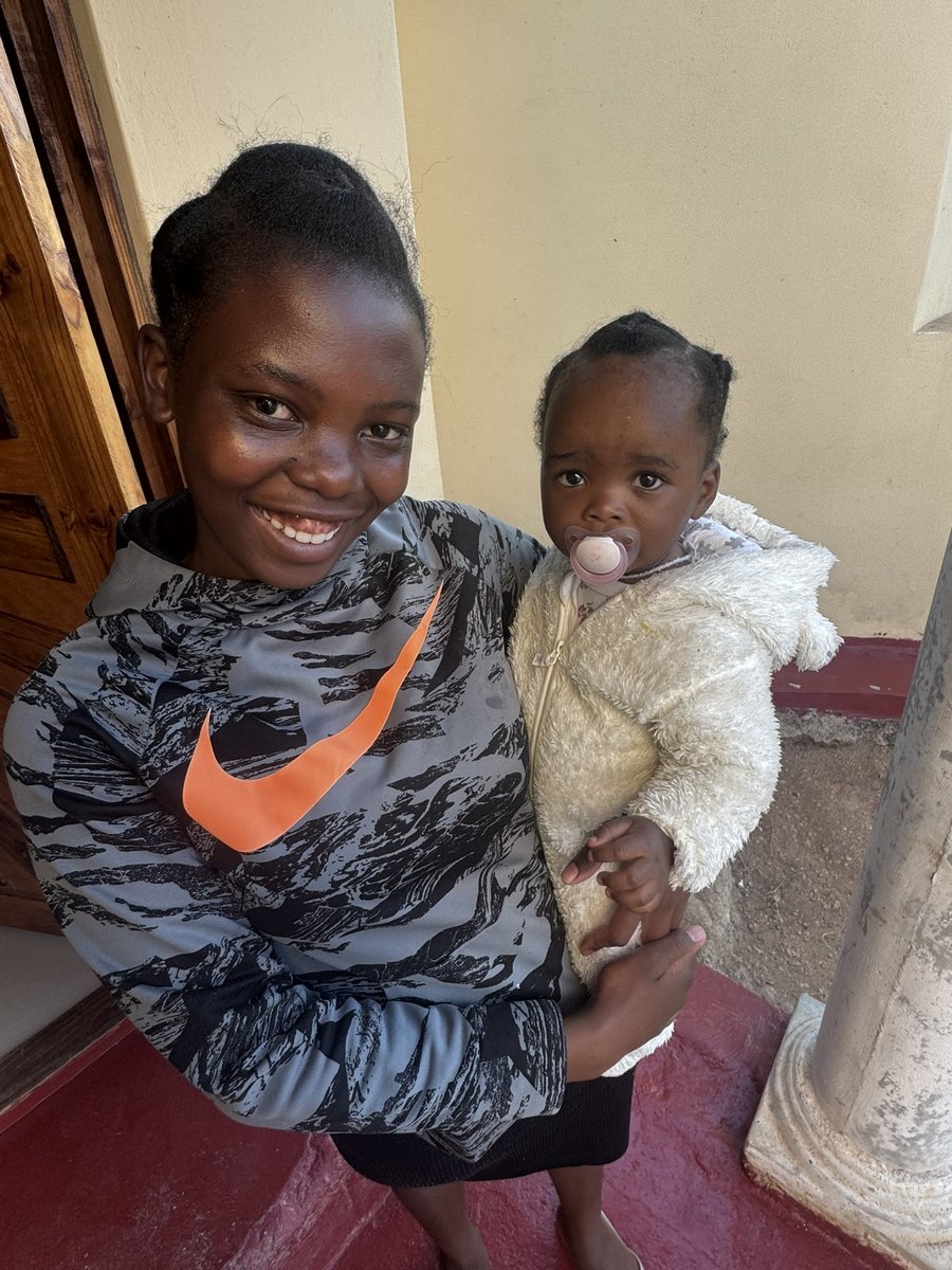 A young mum holding her baby daughter at home