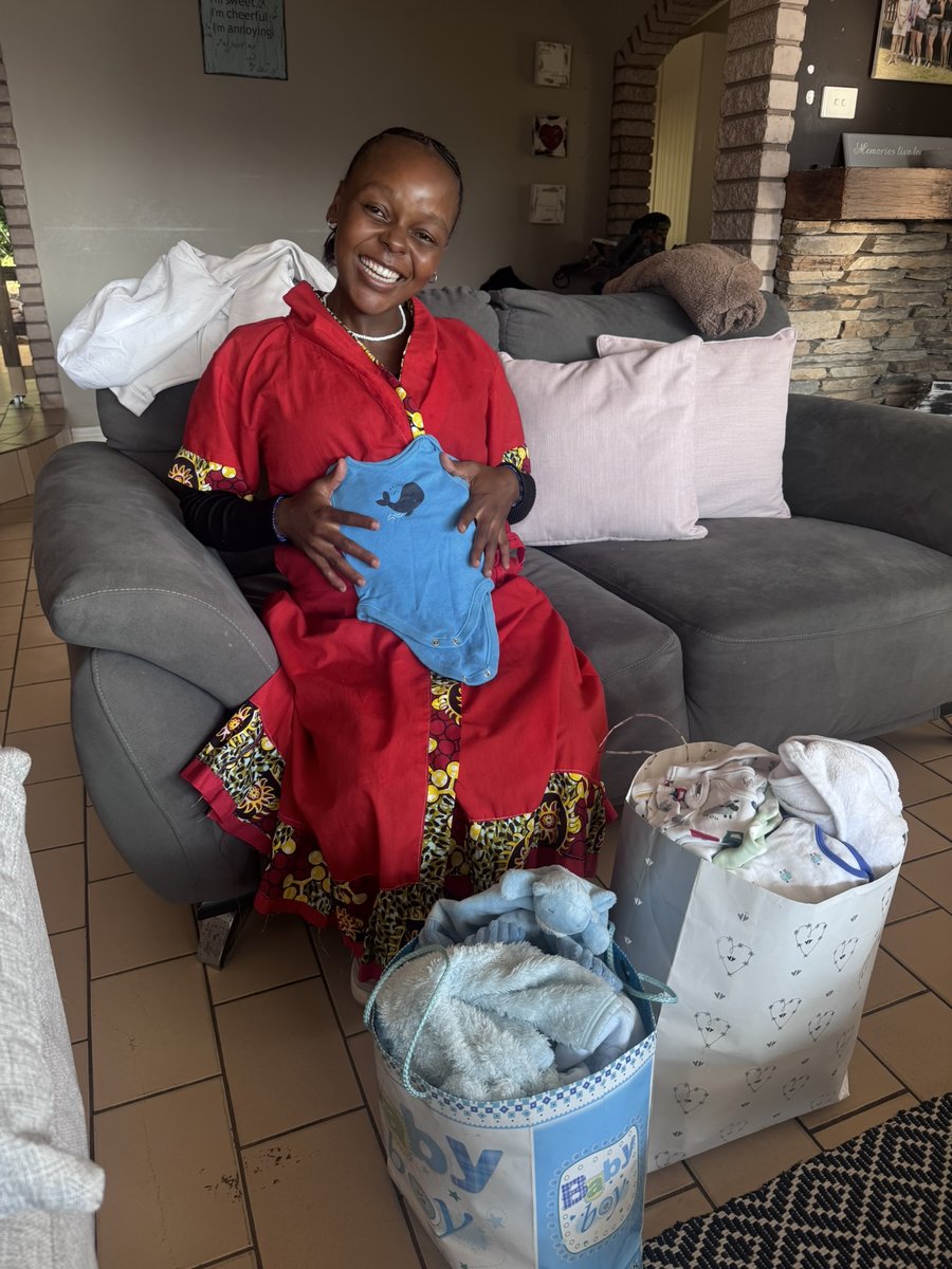 A young mum with baby clothes and essentials from her Mum & Baby Bag