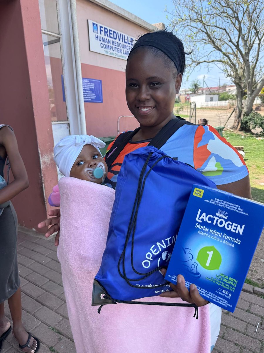 A young mum with her baby, an Opening Doors bag and infant formula